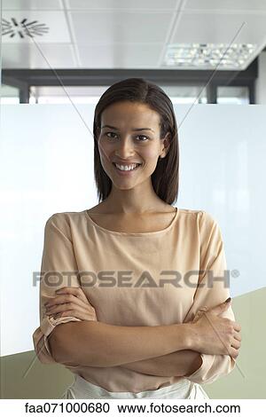 Stock Image - Smiling woman in office, portrait. Fotosearch