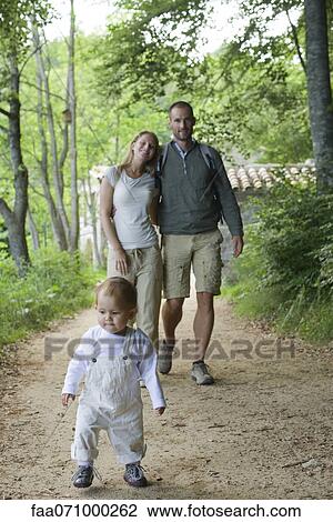 Toddler girl walking in woods with parents View Large Photo Image Stock Image - Toddler girl walking in woods with parents. Fotosearch