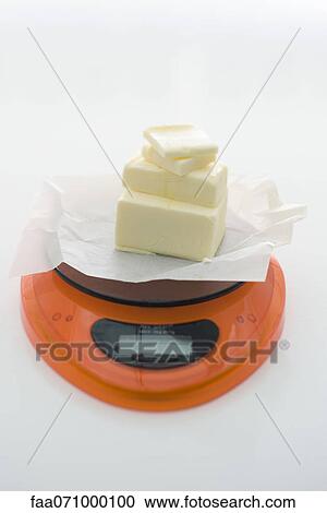 Weighing butter on kitchen scale View Large Photo Image Stock Image - Weighing butter on kitchen scale. Fotosearch