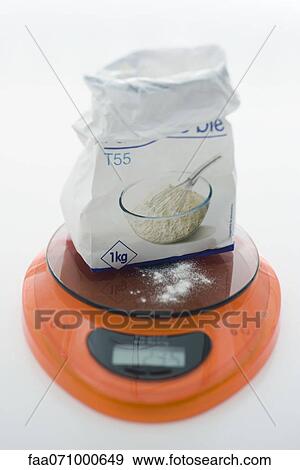Stock Photo - Weighing flour on kitchen scale. Fotosearch