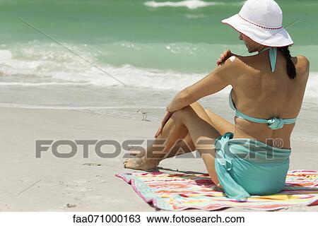 Woman at the beach, applying sunscreen View Large Photo Image Stock Image - Woman at the beach, applying sunscreen. Fotosearch