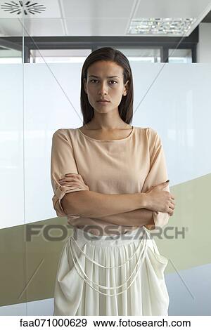 Woman in office with arms folded, portrait View Large Photo Image Stock Photo - Woman in office with arms folded, portrait. Fotosearch