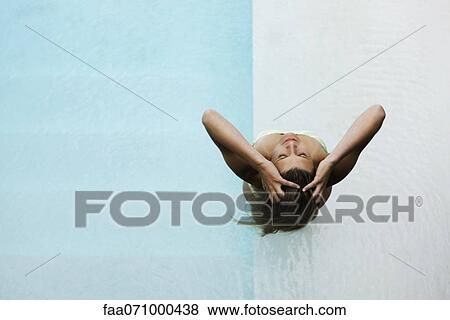 Stock Photo - Woman in wading pool, head back, hands in hair. Fotosearch