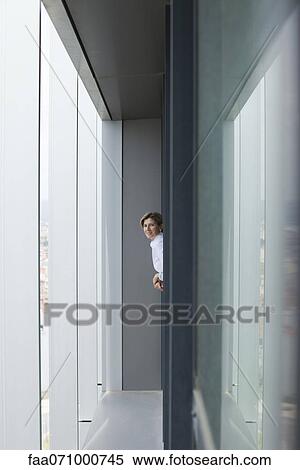 Stock Photography - Woman leaning out of office window. Fotosearch