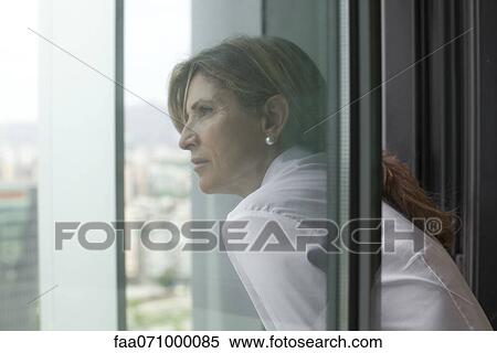 Stock Photography - Woman leaning out of window. Fotosearch
