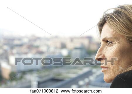 Stock Image - Woman looking at view, side view. Fotosearch