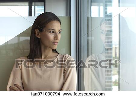 Picture - Woman looking out of window. Fotosearch