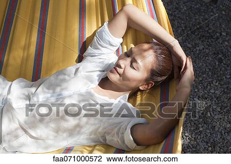 Stock Image - Woman napping in hammock. Fotosearch