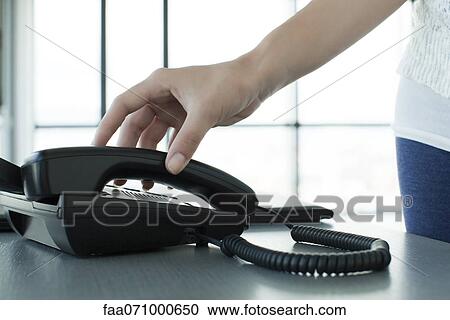 Woman picking up telephone receiver, backlit, cropped View Large Photo Image Stock Image - Woman picking up telephone receiver, backlit, cropped. Fotosearch