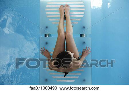 Woman relaxing on swimming pool footbridge View Large Photo Image Stock Image - Woman relaxing on swimming pool footbridge. Fotosearch