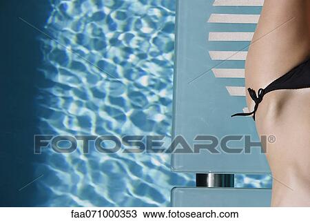 Woman sunbathing by pool, cropped View Large Photo Image Stock Image - Woman sunbathing by pool, cropped. Fotosearch