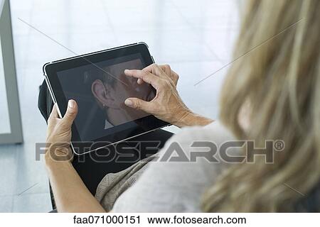 Woman using digital tablet, over the shoulder view View Large Photo Image Stock Image - Woman using digital tablet, over the shoulder view. Fotosearch