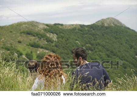 Young family looking at mountain view, rear view View Large Photo Image Stock Photograph - Young family looking at mountain view, rear view. Fotosearch