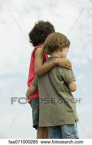 Young siblings standing together outdoors View Large Photo Image Stock Photography - Young siblings standing together outdoors. Fotosearch