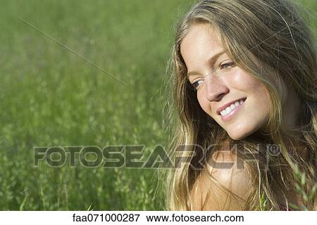 Stock Photo - Young woman daydreaming outdoors, portrait. Fotosearch