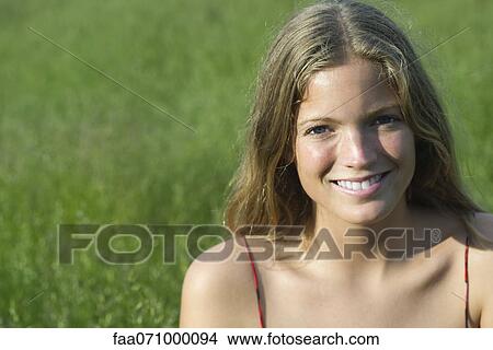 Picture - Young woman smiling outdoors, portrait. Fotosearch