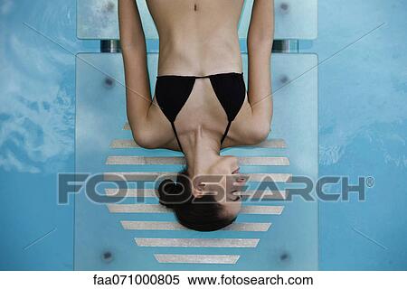 Young woman sunbathing by pool View Large Photo Image Stock Photography - Young woman sunbathing by pool. Fotosearch