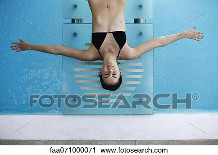 Young woman with arms outstretched sunbathing by pool View Large Photo Image Stock Image - Young woman with arms outstretched sunbathing by pool. Fotosearch