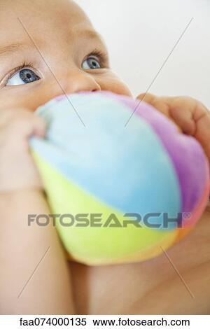 Stock Photography - Baby chewing on stuffed toy. Fotosearch
