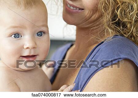Baby in mother's arms, cropped View Large Photo Image Stock Photo - Baby in mother's arms, cropped. Fotosearch