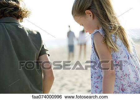Boy and girl at the beach, rear view View Large Photo Image Stock Photograph - Boy and girl at the beach, rear view. Fotosearch