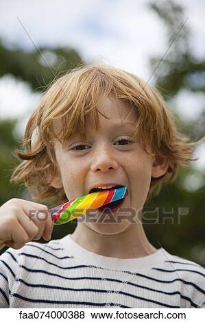 Stock Photo - Boy eating lollipop. Fotosearch