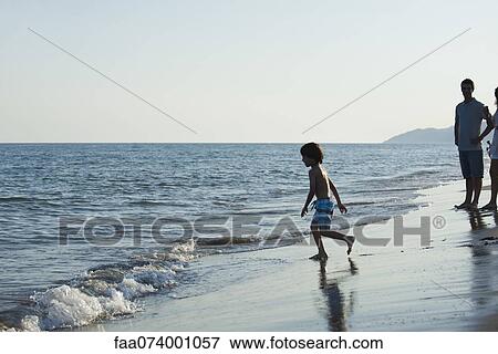 Stock Photo - Boy playing at the beach. Fotosearch