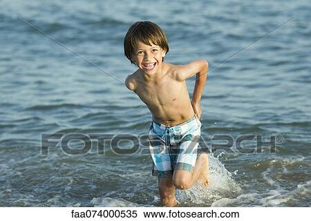 Boy playing in water at the beach View Large Photo Image Stock Photography - Boy playing in water at the beach. Fotosearch