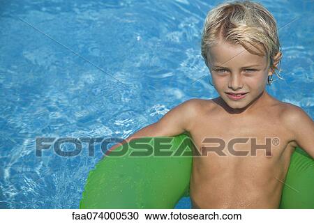 Boy relaxing on float in pool View Large Photo Image Stock Image - Boy relaxing on float in pool. Fotosearch