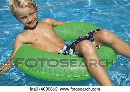 Boy relaxing on float in pool View Large Photo Image Stock Image - Boy relaxing on float in pool. Fotosearch