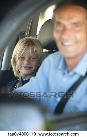 Stock Image - Boy riding in car with father, cropped. Fotosearch