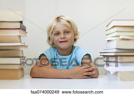 Boy sitting between two stacks of books, portrait View Large Photo Image Stock Photo - Boy sitting between two stacks of books, portrait. Fotosearch