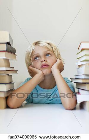 Boy sitting between two stacks of books, daydreaming View Large Photo Image Stock Photography - Boy sitting between two stacks of books, daydreaming. Fotosearch