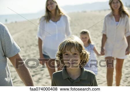 Boy walking at the beach with his family View Large Photo Image Stock Photo - Boy walking at the beach with his family. Fotosearch