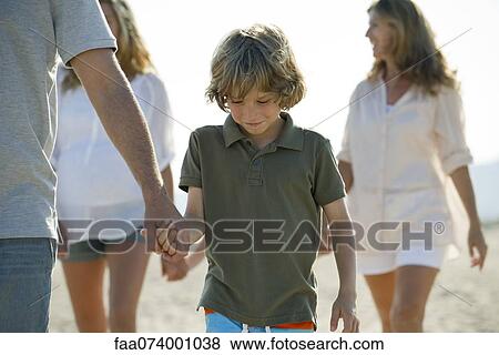 Boy walking on beach with family, holding father's hand View Large Photo Image Stock Photo - Boy walking on beach with family, holding father's hand. Fotosearch