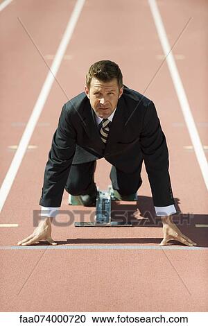 Businessman crouching at starting line on running track View Large Photo Image Stock Image - Businessman crouching at starting line on running track. Fotosearch