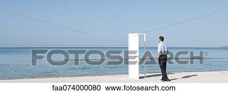Businessman walking on beach towards open door, rear view View Large Photo Image Stock Image - Businessman walking on beach towards open door, rear view. Fotosearch