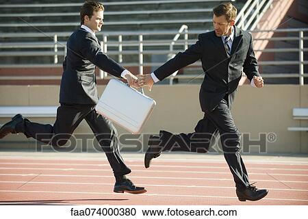 Businessmen handing off briefcase in relay race View Large Photo Image Stock Image - Businessmen handing off briefcase in relay race. Fotosearch