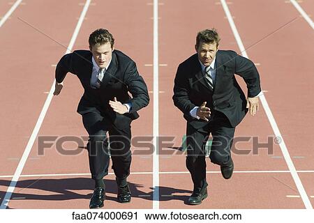 Stock Image - Businessmen racing each other on running track. Fotosearch