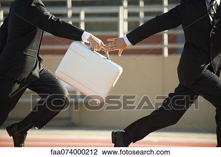 Businessmen running in relay race, handing off briefcase View Large Photo Image Stock Image - Businessmen running in relay race, handing off briefcase. Fotosearch