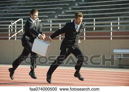 Businessmen running in relay race, handing off briefcase View Large Photo Image Stock Image - Businessmen running in relay race, handing off briefcase. Fotosearch