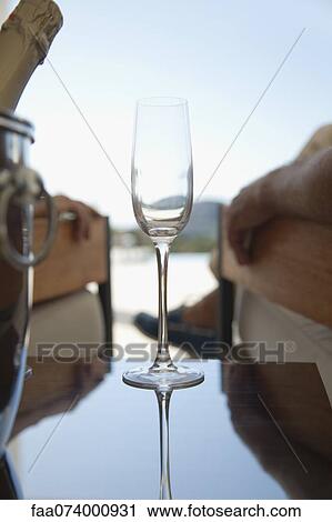 Champagne flute, people relaxing in background View Large Photo Image Stock Image - Champagne flute, people relaxing in background. Fotosearch