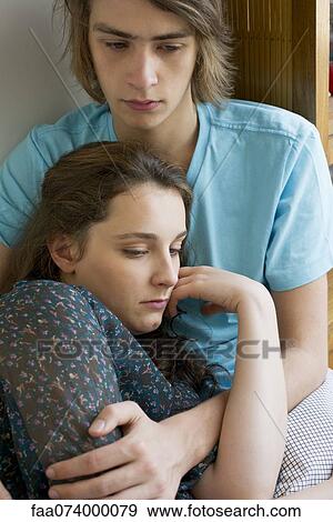 Couple embracing, looking away in thought View Large Photo Image Stock Photo - Couple embracing, looking away in thought. Fotosearch