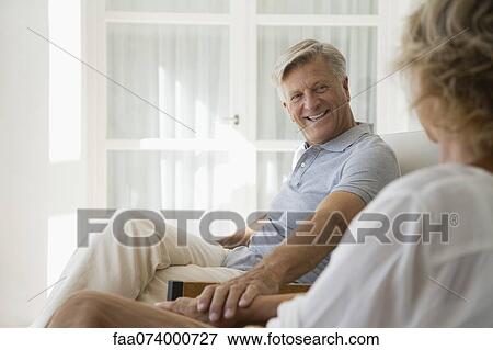 Couple relaxing together in home View Large Photo Image Stock Photo - Couple relaxing together in home. Fotosearch