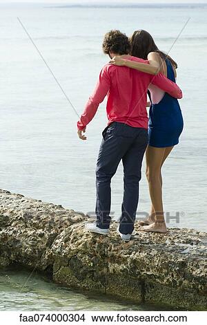 Picture - Couple walking on jetty, rear view. Fotosearch