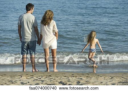Family at the beach, rear view View Large Photo Image Stock Image - Family at the beach, rear view. Fotosearch