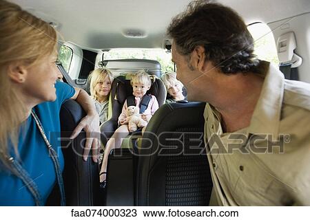Family in car, parents looking over their shoulders at children View Large Photo Image Stock Image - Family in car, parents looking over their shoulders at children. Fotosearch