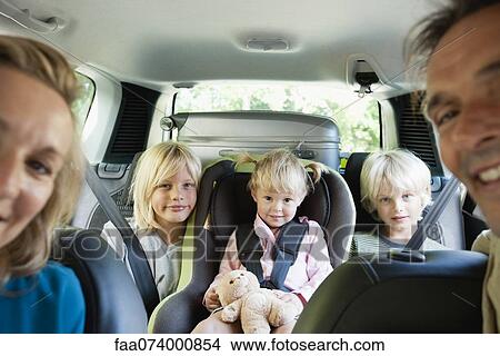 Picture - Family in car, smiling at camera. Fotosearch