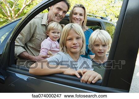 Family posing beside car, looking through open window, portrait View Large Photo Image Stock Photo - Family posing beside car, looking through open window, portrait. Fotosearch