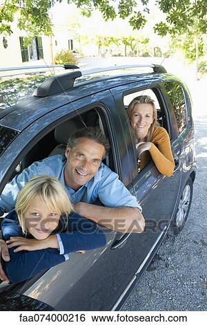 Family together in car, leaning out windows and smiling at camera View Large Photo Image Stock Photograph - Family together in car, leaning out windows and smiling at camera. Fotosearch